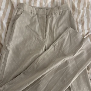 Kostymbyxor  - Beige/vit randiga kostymbyxor ifrån bikbok. Raka i modellen. Storlek 36 och knappt använda 