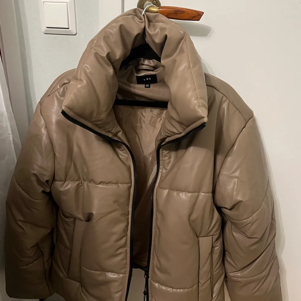 En varm brun/beige vinterjacka från LXA! Aldrig använd så den är i perfekt skick. Storlek XXS men oversize så passar även S-M. Nypris ca 1000 och går ej att köpa längre.. Jackor.