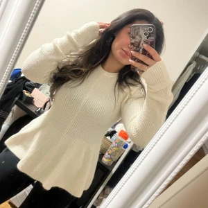 Vit stickad tröja - Säljer en supermysig vit stickad tröja som är perfekt för kyliga dagar. Den har en skön passform med långa ärmar och en lätt utsvängd nederdel som ger en fin siluett. Perfekt för både vardag och mysiga hemmakvällar!