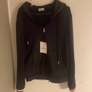 Moncler hoodie  - Säljer min Moncler hoddie i storlek M, inga större defekter lite solblekt. Kan tänka mig gå ner i pris vid snabb och enkel affär.