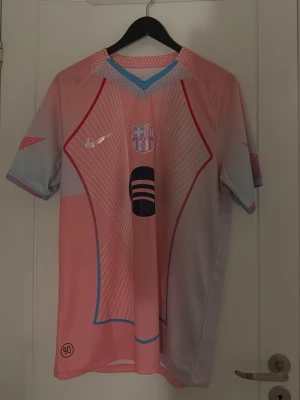 Rosa Barcelona matchtröja Nike - Säljer en rosa och ljuslila Barcelona matchtröja från Nike med klubbmärke och logga på bröstet. Den är i storlek L men skulle säga att den passar M! HELT NY OANVÄND 