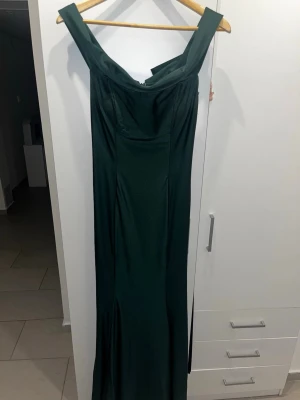 Mörkgrön långklänning för bal/bröllop - Elegant mörkgrön långklänning och figurnära passform. Klänningen har en mjuk, glansig yta och stilren siluett som ger en lyxig känsla. Perfekt för speciella tillfällen där du vill sticka ut.  sjukt snygg klänning för bal eller bröllop etc. använd en gång! köpt för 435$ i USA. 