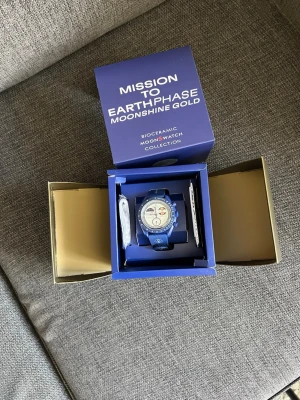 Omega x Swatch MoonSwatch mission to earthphase moonshine gold - Sprillans ny moonswatch. Box och papper följer med. K o p i a!