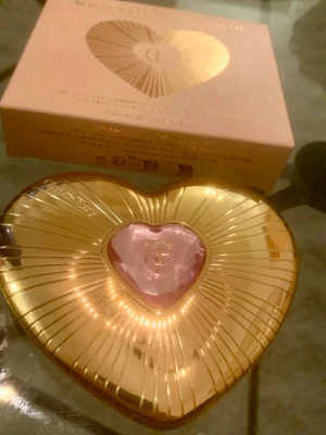 Charlotte Tilbury hjärtformat rouge - Exklusivt rouge från Charlotte Tilbury i en lyxig hjärtformad guldig dosa med rosa detalj i mitten. Förpackningen är elegant och sticker ut på sminkbordet. Perfekt för dig som vill ha en snygg blush med wow-faktor.