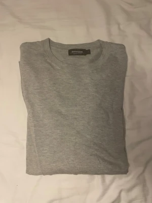 Ljusgrå stickad tröja Dressmann - Snygg ljusgrå stickad tröja från Dressmann i Supima-bomull. Tröjan har rund halsringning, långa ärmar och ribbade muddar vid ärmslut och nederkant. Perfekt basplagg för lager på lager och enkel att matcha med olika stilar.