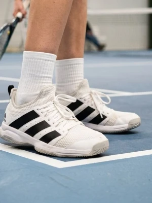 Vita sneakers med svarta ränder - Fräscha vita sneakers från Adidas med klassiska svarta ränder på sidorna. Skorna har mesh- och syntetmaterial för bra andningsförmåga och komfort. Lågt skaft och snörning framtill. Perfekta för en sportig och stilren look. Finns en fläck som kan ses på bild 4