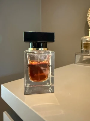 Dolce & Gabbana the only one - Snygg parfym från Dolce & Gabbana i en stilren, fyrkantig glasflaska med svart och guld lock. Doften har en djup bärnstensfärgad vätska som ger en lyxig känsla. Perfekt för dig som gillar exklusiva och eleganta parfymer. Förvarats mörkt och svalt