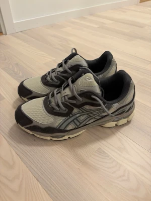 Asics gel nyc grey - Snygga sneakers från Asics i grått och mörkgrått med mesh och mockadetaljer. Skorna har klassisk låg profil, tydliga Asics-loggor på sidorna och bekväm vadderad insida. Perfekta för en sportig och avslappnad stil.