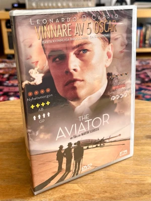 NY / INPLASTAD! The Aviator (DVD) – Vinnare av 5 Oscar! Scorsese! - Helt ny, oöppnad och fabriksinplastad köpfilm på DVD med Martin Scorseses storslagna och hyllade mästerverk ”The Aviator” från 2004. Filmen belönades med hela 5 Oscarsstatyetter och bjuder på ett fantastiskt skådespeleri.