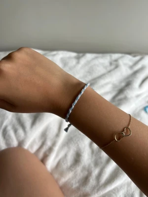 Blåvitt tvinnat vänskapsarmband - Säljer ett handgjort armband i tvinnad blå och vit tråd. Armbandet har knytning med tofsar i ändarna, justerbart och passar perfekt för dig som gillar en enkel och stilren accessoar. Materialet är mjukt och bekvämt mot huden.💕