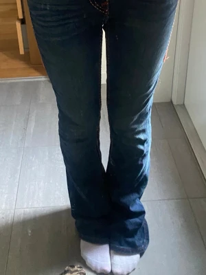 Mörkblå bootcut jeans - Säljer ett par mörkblå bootcut jeans från true religion! Säljer för att de är lite för stora☺️storlek 25 och knappt använda, max 7 gånger.🥰