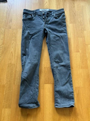Jacob Cohen slim jeans mörkgrå - Mörkgrå slim jeans från Jacob Cohen. Storleken i midjan är 30 och jeansen passar dig som är ca 170-175 lång. Priset är ej hugget i sten!