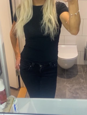 Intimissimi t shirt  - Säljer en svart, tight t-shirt med rund hals och korta ärmar. T-shirten är enkel och stilren, perfekt att matcha med jeans eller kjol. Materialet känns mjukt och stretchigt, vilket gör den bekväm att bära hela dagen.
