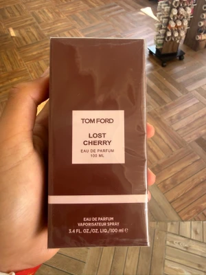 Tom Ford Lost Cherry EdP 100 ml - Tom Ford Lost Cherry Eau de Parfum 100 ml är en lyxig parfym i en elegant mörkröd förpackning med vita detaljer. Doften är känd för sina söta och fruktiga toner av körsbär och mandel, vilket ger en unik och djärv karaktär. Perfekt för dig som vill sticka ut.