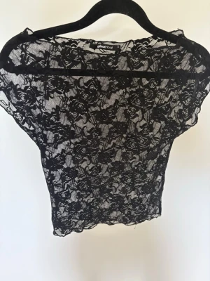 Spelstopp Gina tricot - Säljer en svart, genomskinlig spetsblus från Gina Tricot i storlek XS. Toppen har ett blommigt spetsmönster och är kortärmad med en tight passform. Funkar både att ha över bh eller linne. 