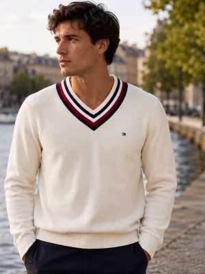 Tommy Hilfiger V-ringad tröja 100% bomull – storlek M - Klassisk Tommy Hilfiger-tröja i krämvit/off-white färg med snygg V-ringning i marinblått, vitt och rött. Broderad Tommy Hilfiger-logga på bröstet.  Storlek M. 100% bomull. Mjuk och bekväm kvalitet. Ribbade muddar och nederkant. Tidlös preppy/college-stil. Fint begagnat skick.  Passar perfekt till jeans, chinos eller över en skjorta.