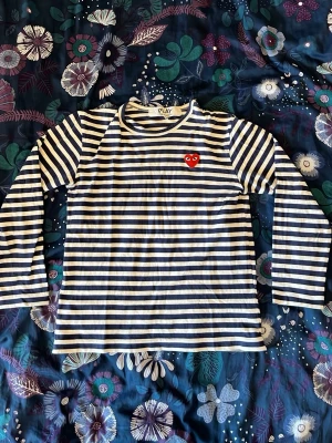 CDG tröja - Populär långärmad tröja från Comme des Garçons i fint skick utöver ett pytte litet hål i nacken som knappt syns (se bild). Storlek M men passar snarare xs kanske s.