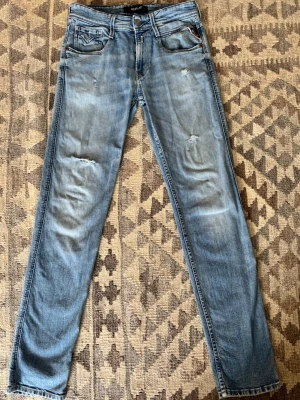Replay jeans blå - Säljer ett par ljusblå jeans med små slitningar på låren och knäna. Mycket bra skick lapp har lossnat lite men inget som försämrar jeansen. Storlek 29/32
