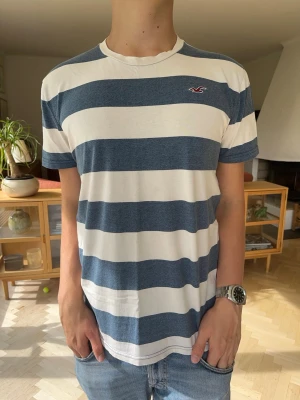 Hollister T-shirt randig blå vit herr - Hollister randig t-shirt i fint skick. Klassiskt marinblå och vitrandig med den ikoniska loggan på bröstet. Mjukt och skönt material, perfekt till ett par jeans eller shorts i sommar.Märke: HollisterSkick: Mycket bra skick#hollister #randigt #tshirt #sommar #marinblå #casual #herrkläder #vintedse #trendig #skön