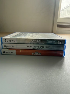 PS5 spelpaket: Avatar, Witcher 3, Funko - Säljer tre PlayStation 5-spel: Avatar Frontiers of Pandora Special Edition, The Witcher 3: Wild Hunt Complete Edition och Funko Fusion. Alla spel kommer i sina originalfodral med färgstarka omslag och tydliga PS5-märkningar. Perfekt för dig som vill ha action, äventyr och partyspel.