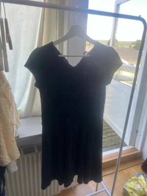 Svart glittrig kortklänning - Säljer en svart kortklänning med glittrigt tyg och korta ärmar. Klänningen har en enkel, figurnära passform och är perfekt för dig som vill sticka ut lite extra. Materialet känns mjukt och stretchigt, vilket gör den bekväm att bära. Supersnygg till alla tillfällen! Stor i storleken!