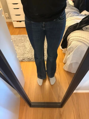 Blå bootcut jeans - Säljer ett par blå bootcut jeans med snygg broderad detalj på bakfickan. Lågmidajde!