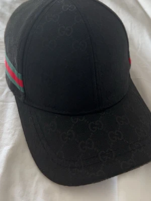 Svart Gucci keps - Säljer denna fräscha och perfekta formade Gucci kepsen. Har haft den i 1 månad och funkar till varenda outfit. Funkar till orten, grisch eller vilken stil som helst. Skriv om du är intresserad. Kan sänka priset vid snabbaffär. 