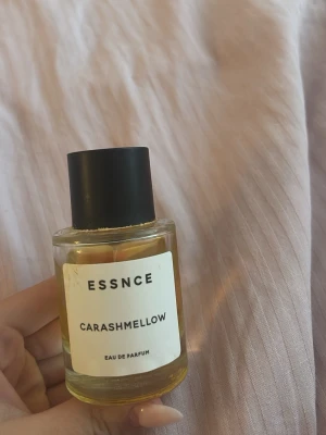 Essnce parfym carashmellow - 50 ml och använd som på bilden, det har torkat parfym där det är lite klistrigt på parfym flaskan som man ser, kommer torka bort det innan leverans! 