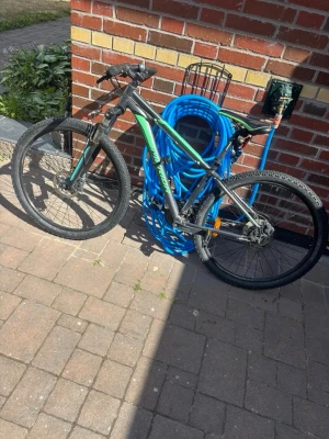 Svart och grön mountainbike - Säljer en svart och grön mountainbike med grova däck och skivbromsar. Cykeln har en sportig ram och raka styren, perfekt för dig som gillar att cykla i terräng eller på grusvägar. Passar både till träning och äventyr.