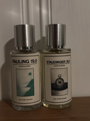 Parfym Pauling 19.0 & Staudinger 35.0 50 ml - Två stilrena parfymflaskor, Pauling 19.0 och Staudinger 35.0, med silvriga lock och minimalistiska etiketter. Flaskorna är genomskinliga och har grafiska illustrationer på framsidan. Perfekt för dig som gillar unika dofter och snygg design. Båda är oanvända med 50 ml var i sig. Ord pris per parfym är 349 kr så sammanlag 698 ord pris.