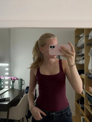 Vinröd body med djup rygg  - Säljer en enkel och stilren vinröd body med djup rygg. Materialet känns mjukt och stretchigt, perfekt att styla till jeans eller kjol. 