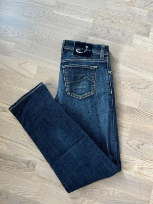 Jacob Cohen jeans w36 - Superfina populära och eftertraktade Jacob Cohen jeans säljes i w36. 103 cm total längd och 45/46 cm breda i midjan. Otroliga jeans unik badge! Inga hål eller fläckar i utmärkt skick och tveka inte vid minsta fråga eller fundering!