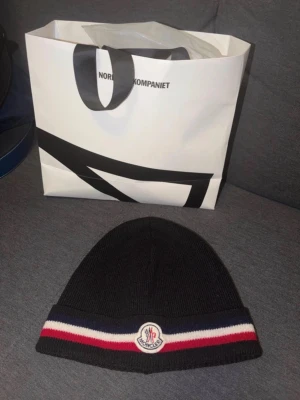 Moncler beanie mössa - Hej! Säljer en moncler mössa i färgen marinblå  Storlek one-size skick 9/10 hör av er för mer info///  Äktehetsbevis finns!!!!