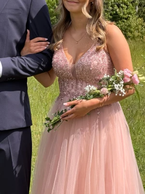 Balklänning - Jätte fin gammaldags rosa balklänning, från Dream Design i Motala. Original pris 5500kr, mitt pris 2500kr. Klänningen är i storlek 34 och har snörning där bak så att man kan justera utifrån sin kroppsform.🌸  Original prislapp skickas med.  Jag har använt klänningen på min studentbal 2026 och den är i mycket fint skick, finns inga skavanker alls på den. Den är som ny!
