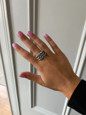 Edblad spikring i silver  - Cool spikring,  silverfärgad metall med flera små konformade nitar på ovansidan. Ringen har en chunky och edgy design som verkligen sticker ut och passar perfekt för dig som gillar statement-smycken. Metallfinishen ger en modern och tuff känsla.