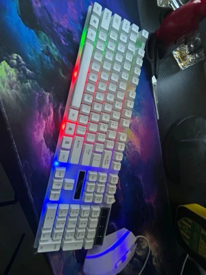 Vit gaming tangentbord  - Snyggt vitt mekaniskt tangentbord med RGB-belysning i flera färger som lyser längs sidorna. Tangentbordet har en kompakt design och vita keycaps med tydliga tecken. Perfekt för gaming eller skrivarbete. Levereras med matchande vit mus. Nytt helt nytt inte använd säljer för behöver pengar