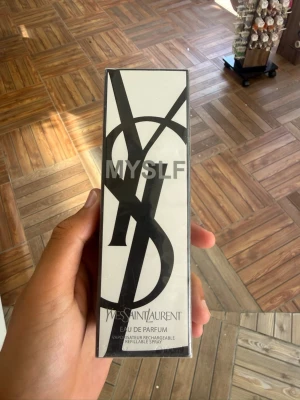 Yves Saint Laurent MYSLF Eau de Parfum - Säljer en elegant parfym från Yves Saint Laurent, MYSLF Eau de Parfum. Flaskan kommer i en stilren svart och vit förpackning med stora YSL-bokstäver och modern design. Parfymen är en spray och förpackningen är påfyllningsbar.