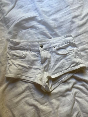 Vita jeansshorts med fickor - Snygga vita jeansshorts med fyra fickor och bälteshällor. Klassisk knapp- och dragkedjestängning framtill. Kort modell som passar perfekt till sommaren. Materialet är denim med stretch för extra komfort. Lågmidjade.