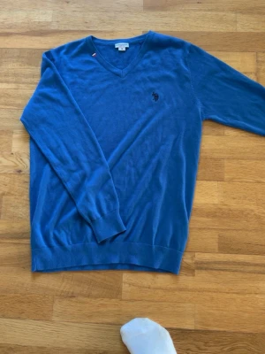 Blå stickad tröja från U.S. Polo Assn. - Köpte tröjan för 2 år sedan. Testade den o sedan tyckte ja den va lite för tight för mig. Aldrig andvänt så bara o slå till. Kan sänka i pris