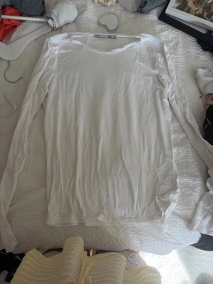 Vit långärmad topp från 157 - En basic vit långärmad topp från 157 med rund halsringning. Tillverkad i mjukt material som passar perfekt till lager på lager eller som den är. Enkel och stilren design utan mönster eller detaljer.