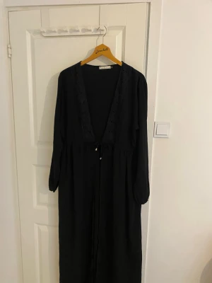 Svart abaya - En svart lång abaya man kan knyta med lite detaljer där uppe