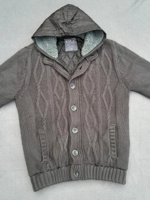 Fodrad cardigan  - Riktigt snygg mönsterstickad fodrad cardigan med både dragkedja och knappar. Storlek XL men sitter som L. Skulle rekommendera att man är runt 185-195. Bra skick, förutom hål i fodret på ärmen men inget man tänker på vid användning. Sista bilden visar färgen bäst.