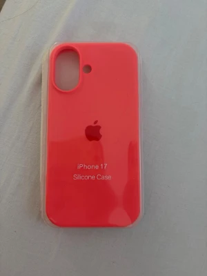  iPhone 17 mobilskal korall - Snyggt rosa mobilskal i silikon till iPhone 17. Skalets yta är mjuk och greppvänlig med ett Apple-logo tryck på baksidan. Passar perfekt för dig som vill ha ett stilrent och färgglatt skydd till din mobil. Korall färg