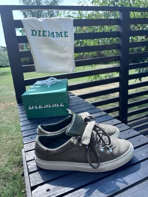 Olivgröna sneakers från Diemme - Snygga olivgröna sneakers från Diemme i mocka med vita sulor och metallhakar för snörningen. Skorna har en robust känsla och outdoor-inspirerade detaljer. Perfekta för dig som gillar streetwear med en twist. Levereras med originalkartong och dustbag. De är även helt ny tvättade och borstade. Ingår även ett helt nytt skosnöre i färgen vit! Nypris är 3700kr så bra pris. Skorna har storlek 40 men passar mig som har 42!