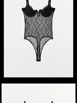 Svart spetsbody med bygel - Snygg svart body i genomskinlig spets med bygelkupor och smala axelband. Hög skärning vid benen och dekorativt mönster i spetsen ger en sexig look. Perfekt för dig som vill ha något extra under kläderna.