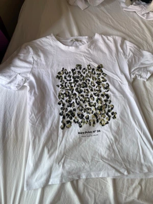 Vit t-shirt med leopardmönster - Säljer en vit t-shirt med leopardmönster från Zara. T-shirten har rund hals och korta ärmar. Köpt från en annan säljare , men passa inte mig🙃. Pris kan diskuteras!! 