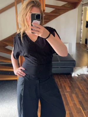 V-ringad topp H&M - Svart v-ringad topp från H&M med korta, vida ärmar och slits 💝