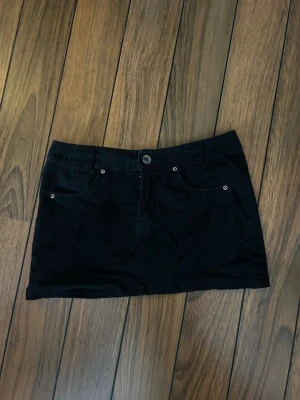 Svart minikjol - Svart snygg jeanskjol med fina detaljer på fickorna