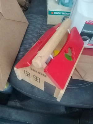 Trälåda med färgglada djur från Kids-Wood - Säljer en söt trälåda formad som ett hus med rött tak och handtag. Inuti finns färgglada djurfigurer i trä, bland annat får i olika färger. Perfekt för lek och sortering. Taket har utskurna former för att passa djuren.
