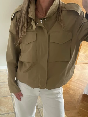 Beige Jacka - Snygg beige jacka. Har justerbara band innuti. Även en inbyggd luva i kragen som man kan ta ut eller ha där i. Aldrig använd!💞
